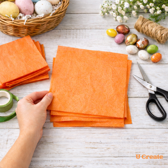 Cutting orange tissue paper squares for DIY Easter carrot treat bags